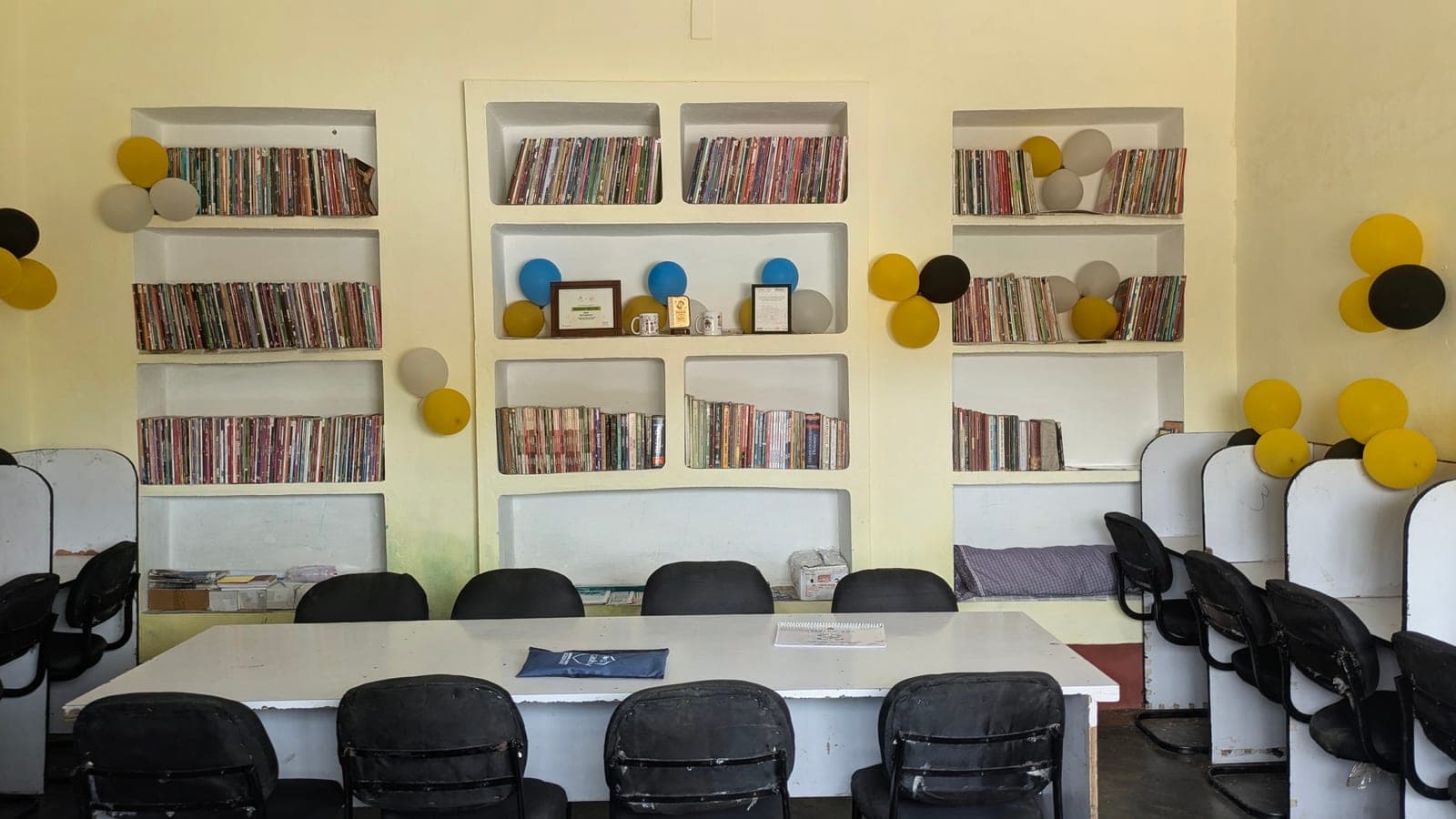 The GyanKutir reading room with filled bookshelves, a long study table, and study desks