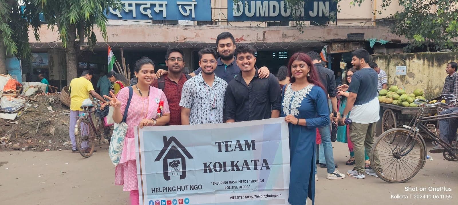 Helping Hut volunteers holding the Team Kolkata banner during an outreach drive outside Dum Dum Junction railway station