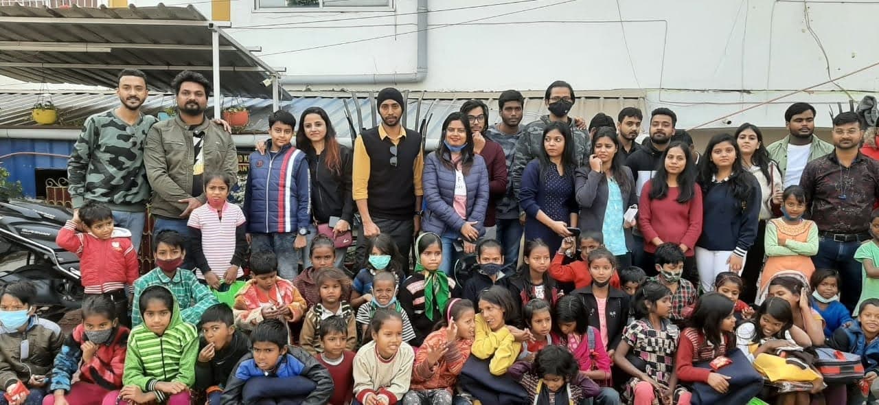 Helping Hut volunteers posing with dozens of local children at a community outreach event in Patna